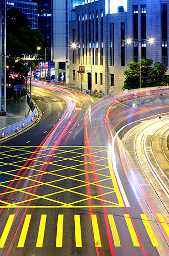 blurred vehicles drive through city streets